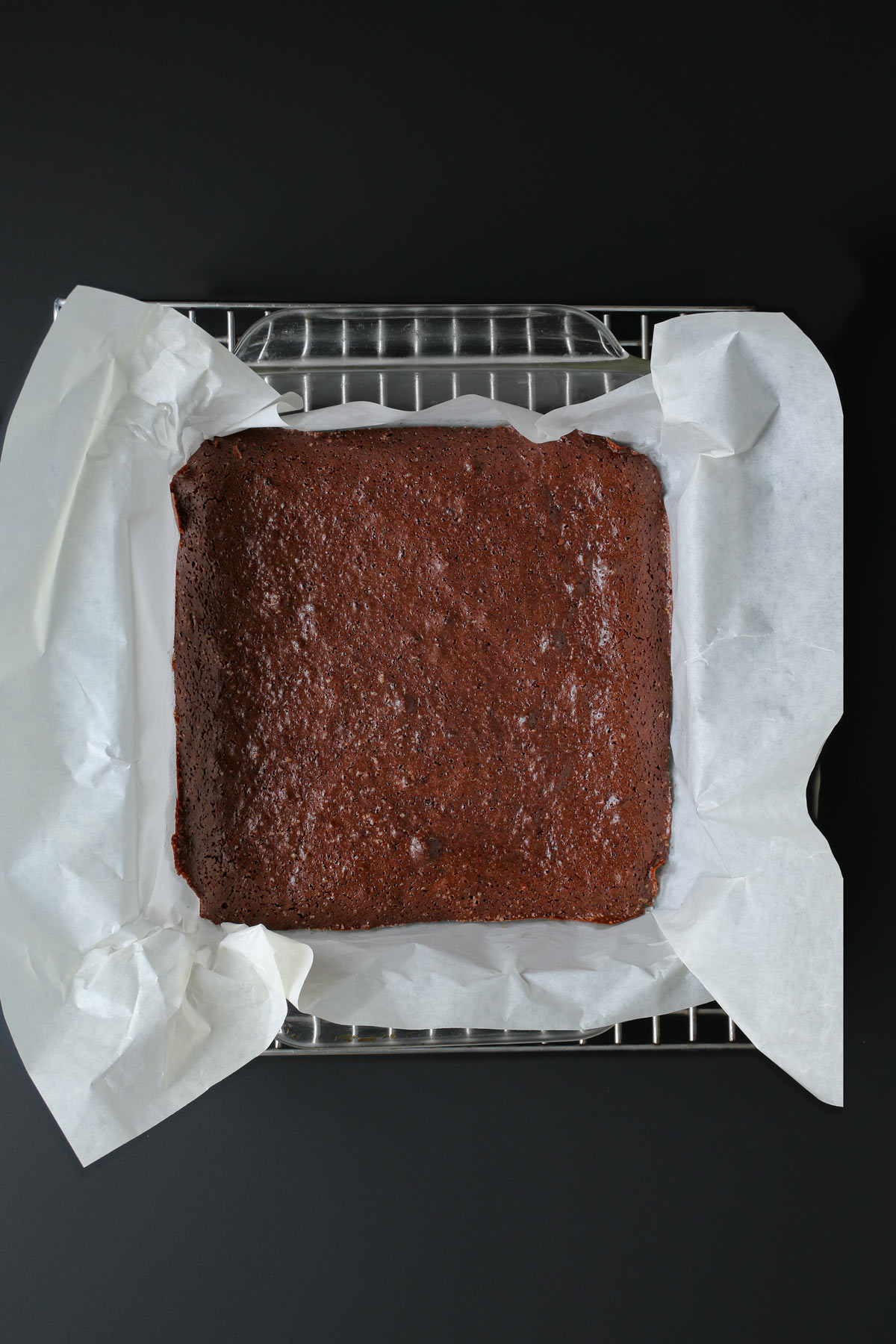 baked brownie layer cooling on a rack.