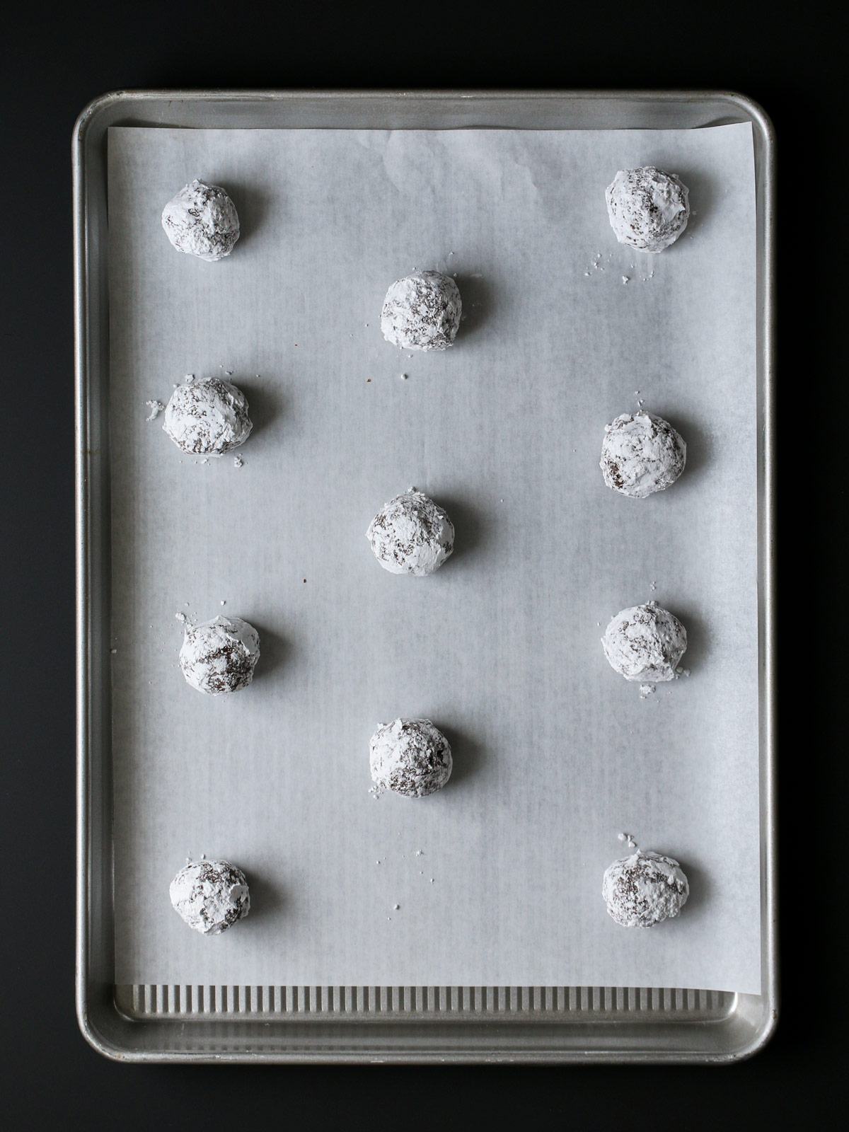 cookie dough balls on lined baking sheet.