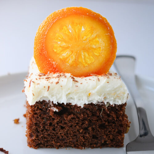close up of chocolate orange cake square on a plate.