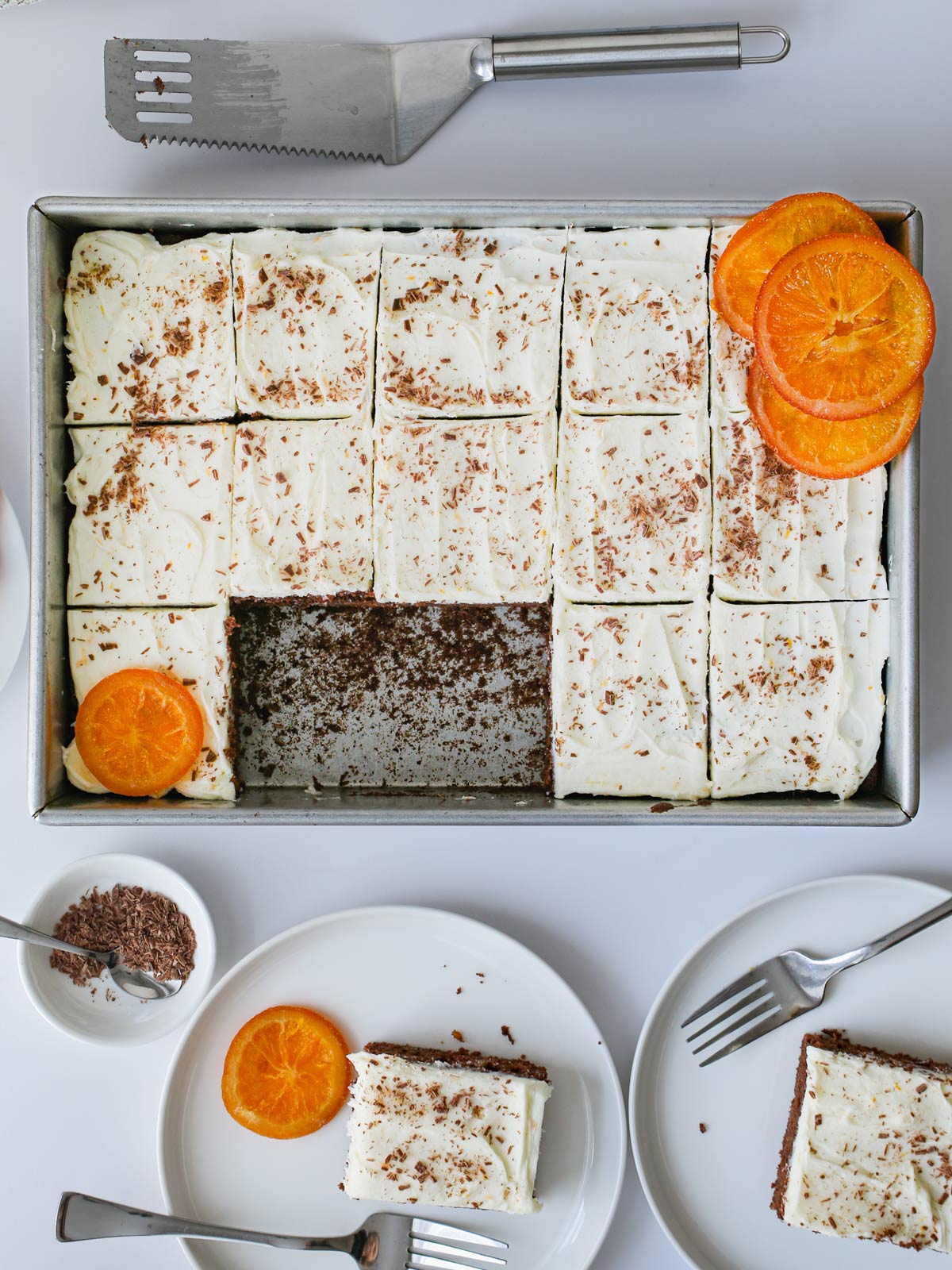 a frosted sheet cake topped with orange buttercream frosting and candied oranges.