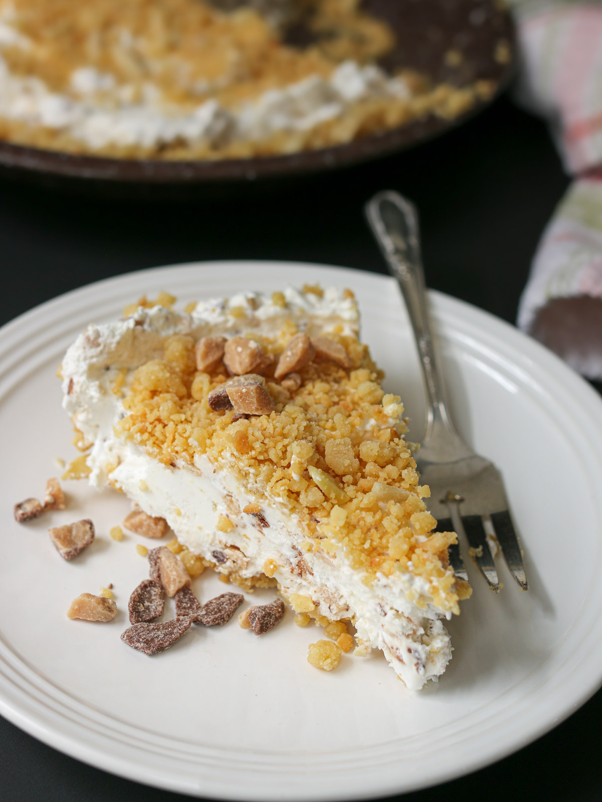 slice of marshmallow pie with toffee bits on a plate with a fork.