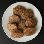 breakfast sausage patties on a white plate.