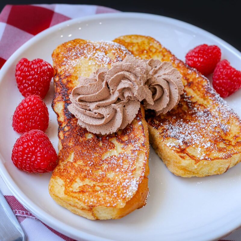 swirls of chocolate whipped cream on french toast.