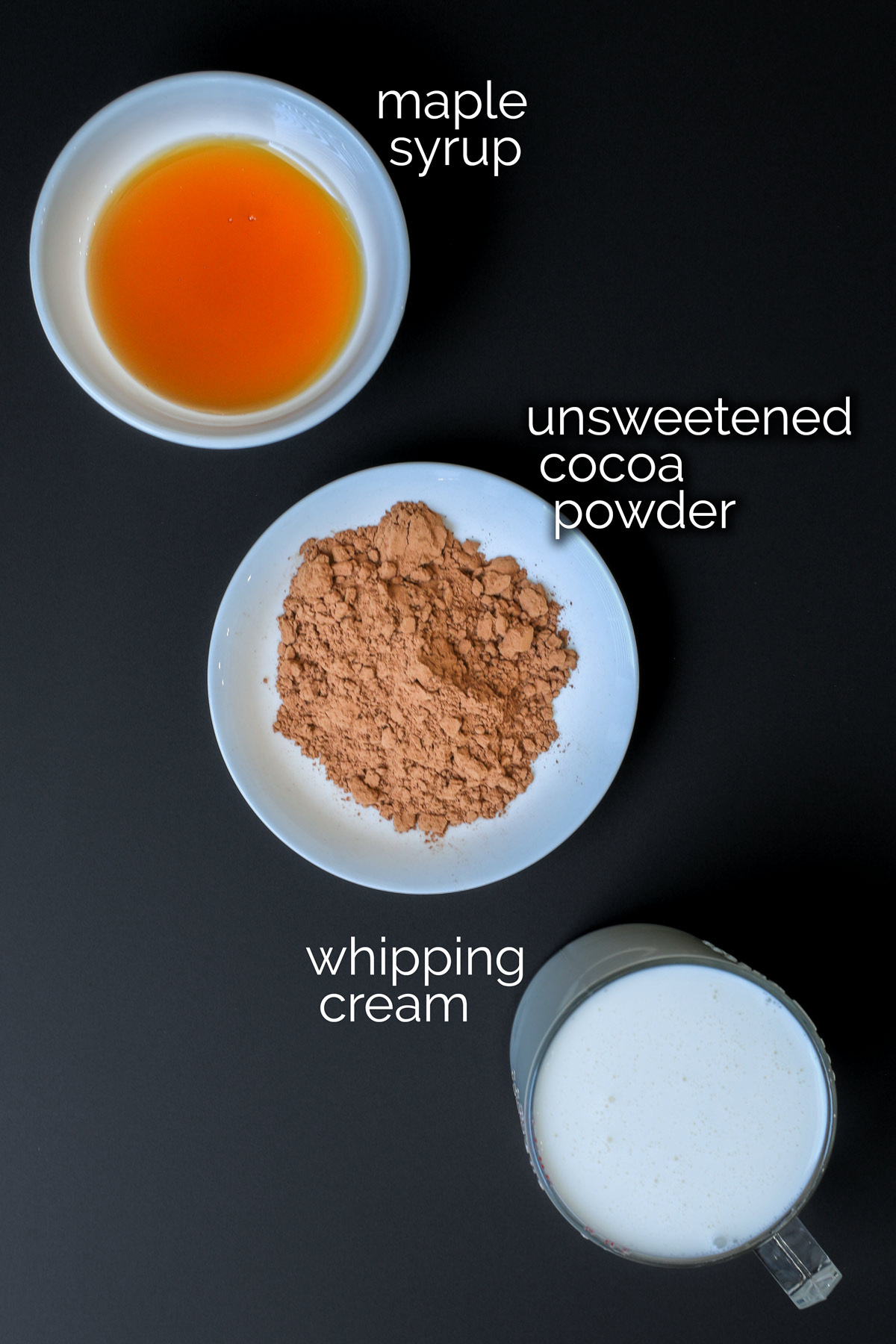 ingredients for chocolate whipped cream on black counter.