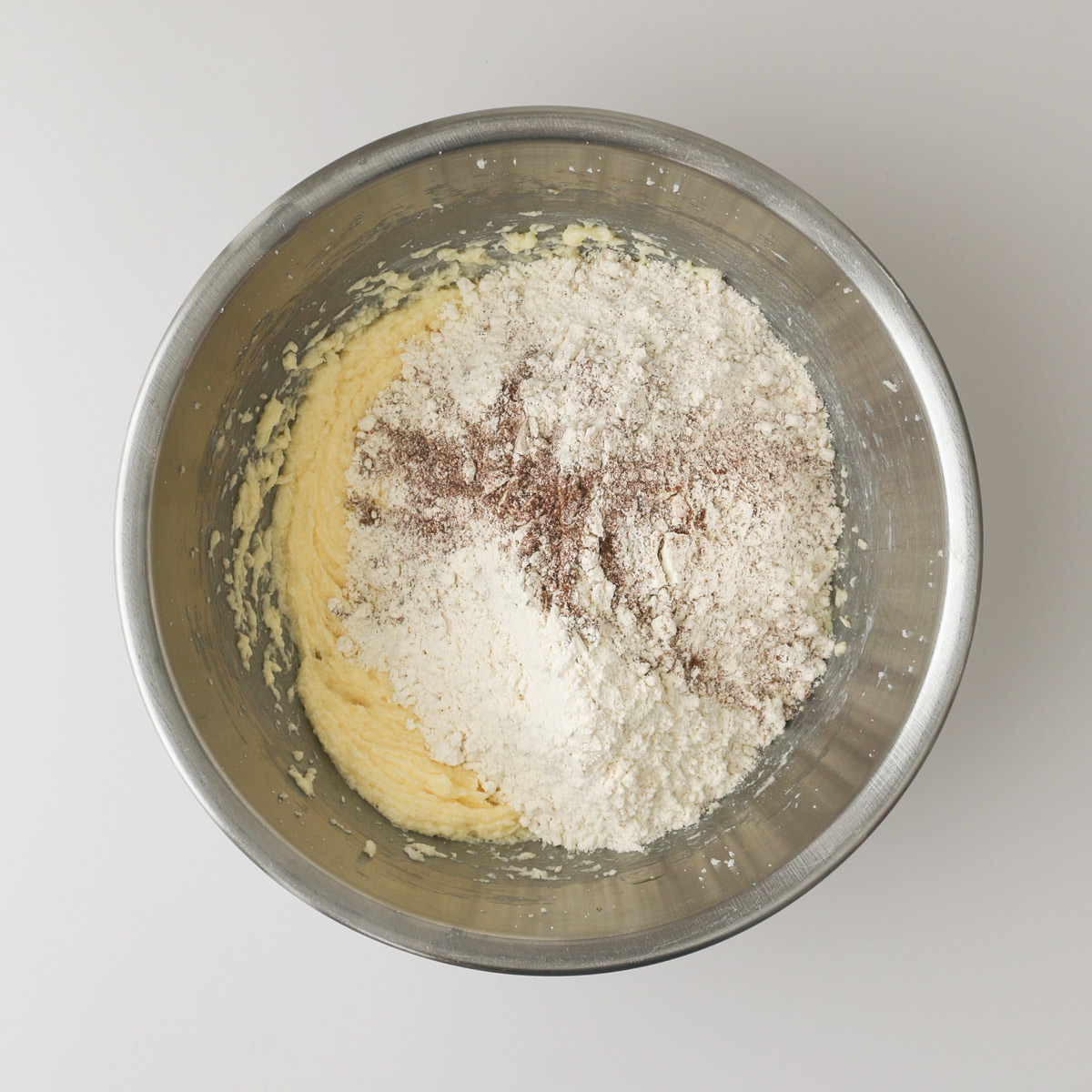 adding dry mixture to butter mixture in mixing bowl.