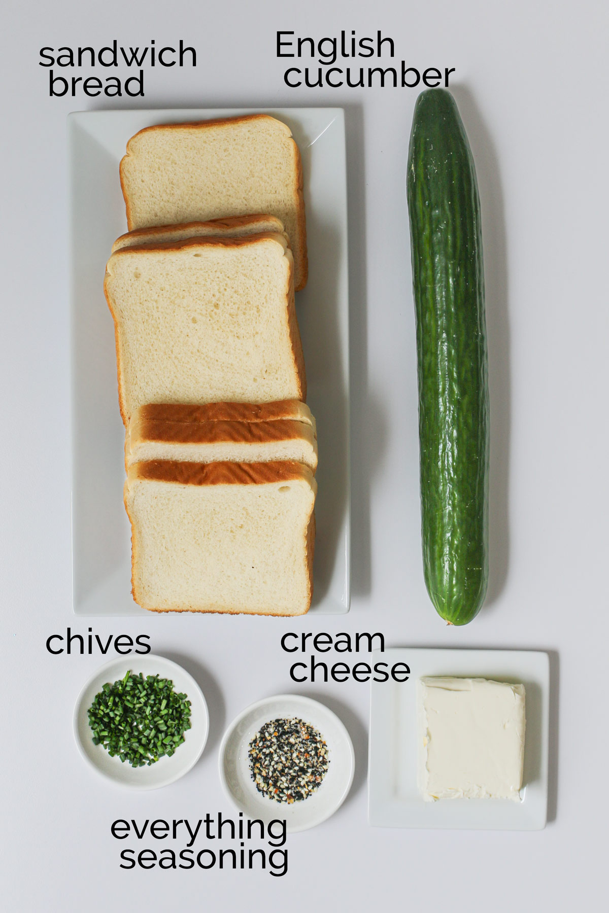 ingredients for cucumber and cream cheese sandwiches on white counter.