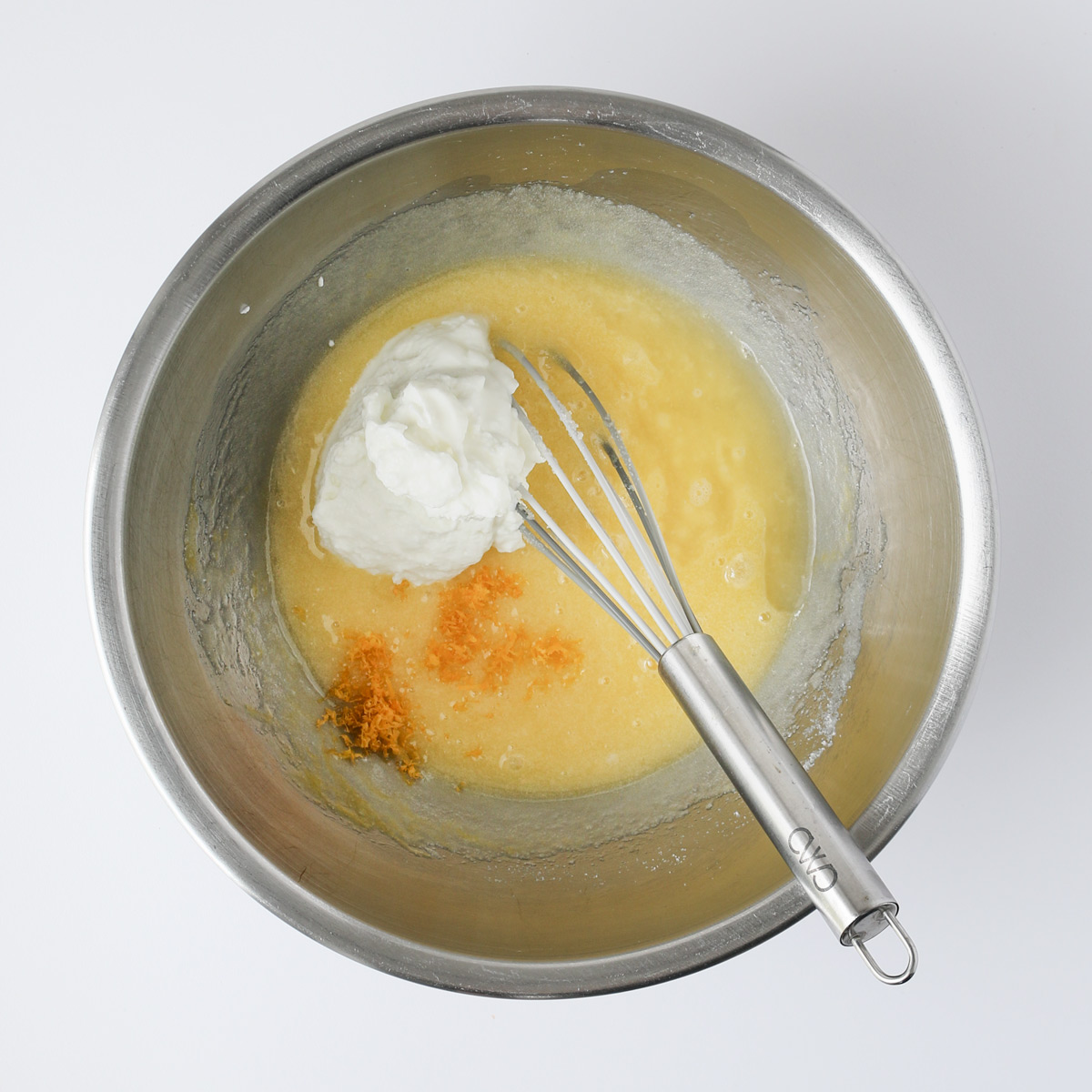 lemon zest and yogurt added to sugar mixture, with whisk, in mixing bowl.