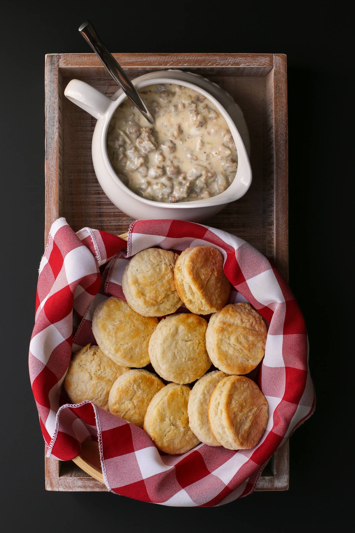 tray with a basket of biscuits and a saucier of gravy.