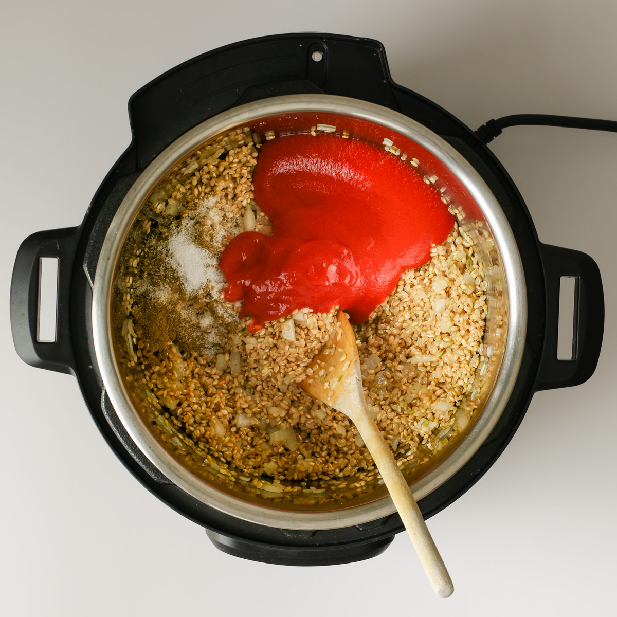 adding sauce and spices to instant pot.