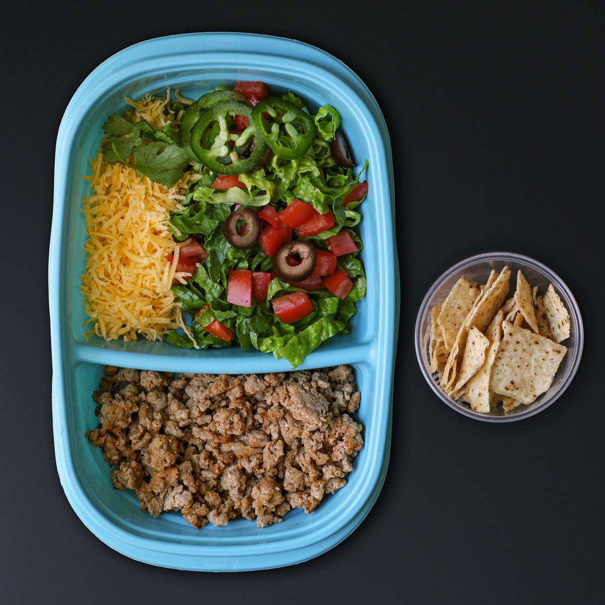 turkey taco salad prepped in meal prep containers.