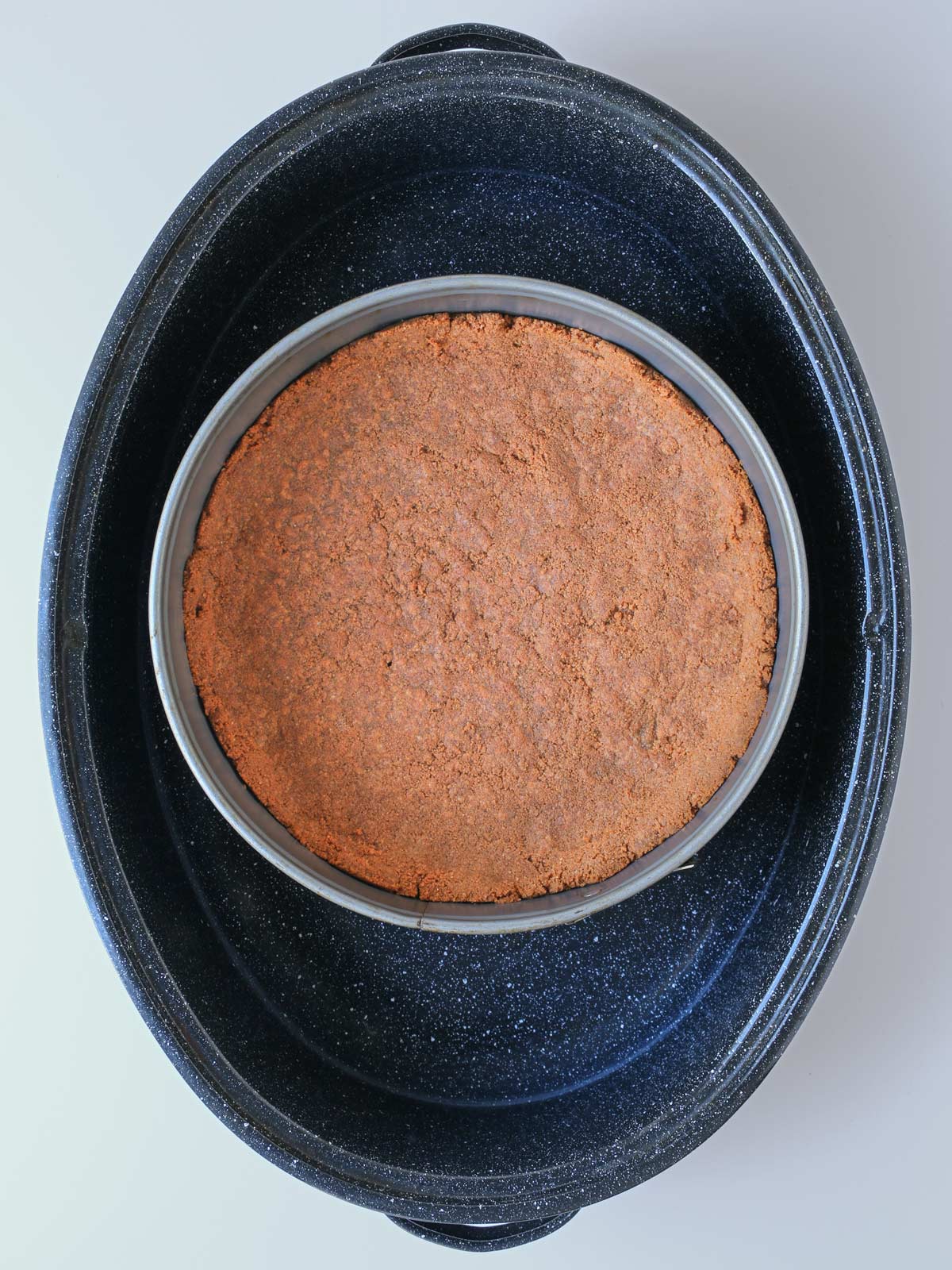 baked crust in springform pan set atop foil coil.