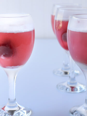 goblets of raspberry sherbet punch on a white table.
