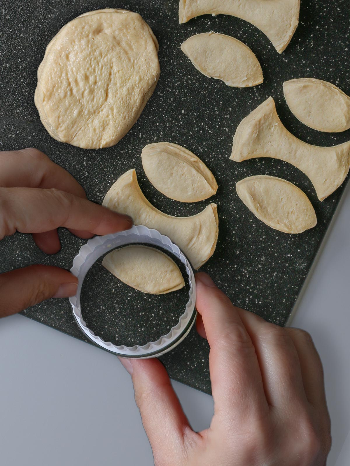 cutting biscuits into shapes with biscuit cutter.