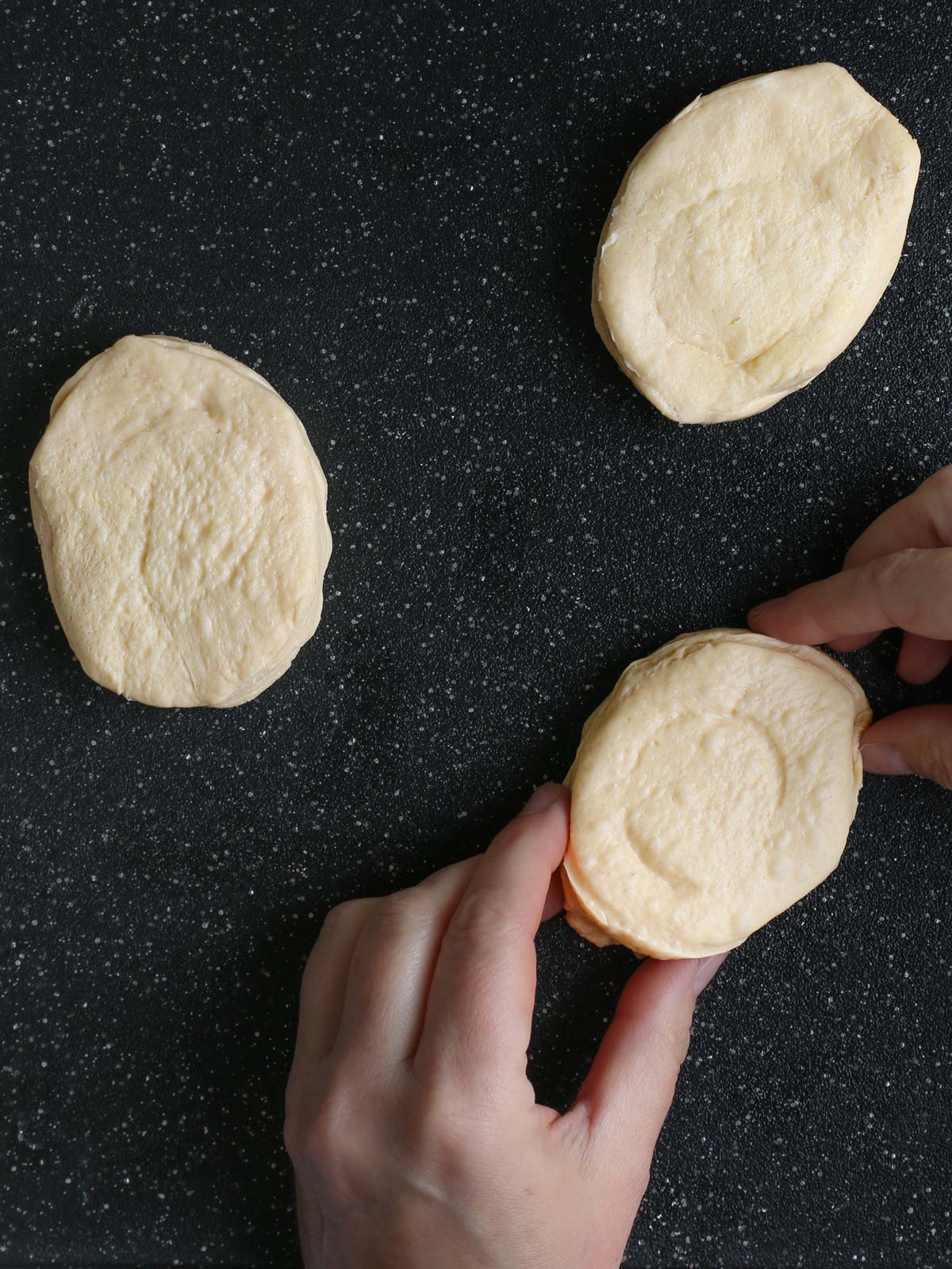 reshaping biscuits into oval egg shapes.