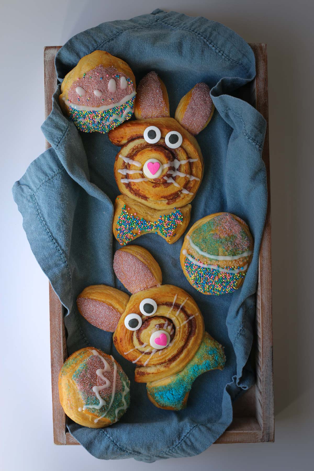 bunny rolls and Easter egg biscuits in blue cloth-lined basket.