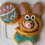 easter bunny cinnamon roll and Easter egg biscuit on white plate.