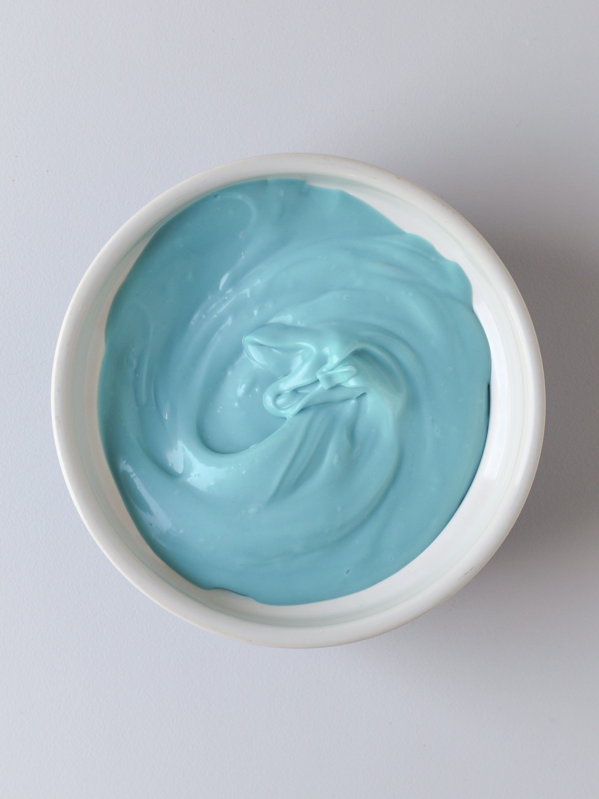 melted blue candy melts in white dish.