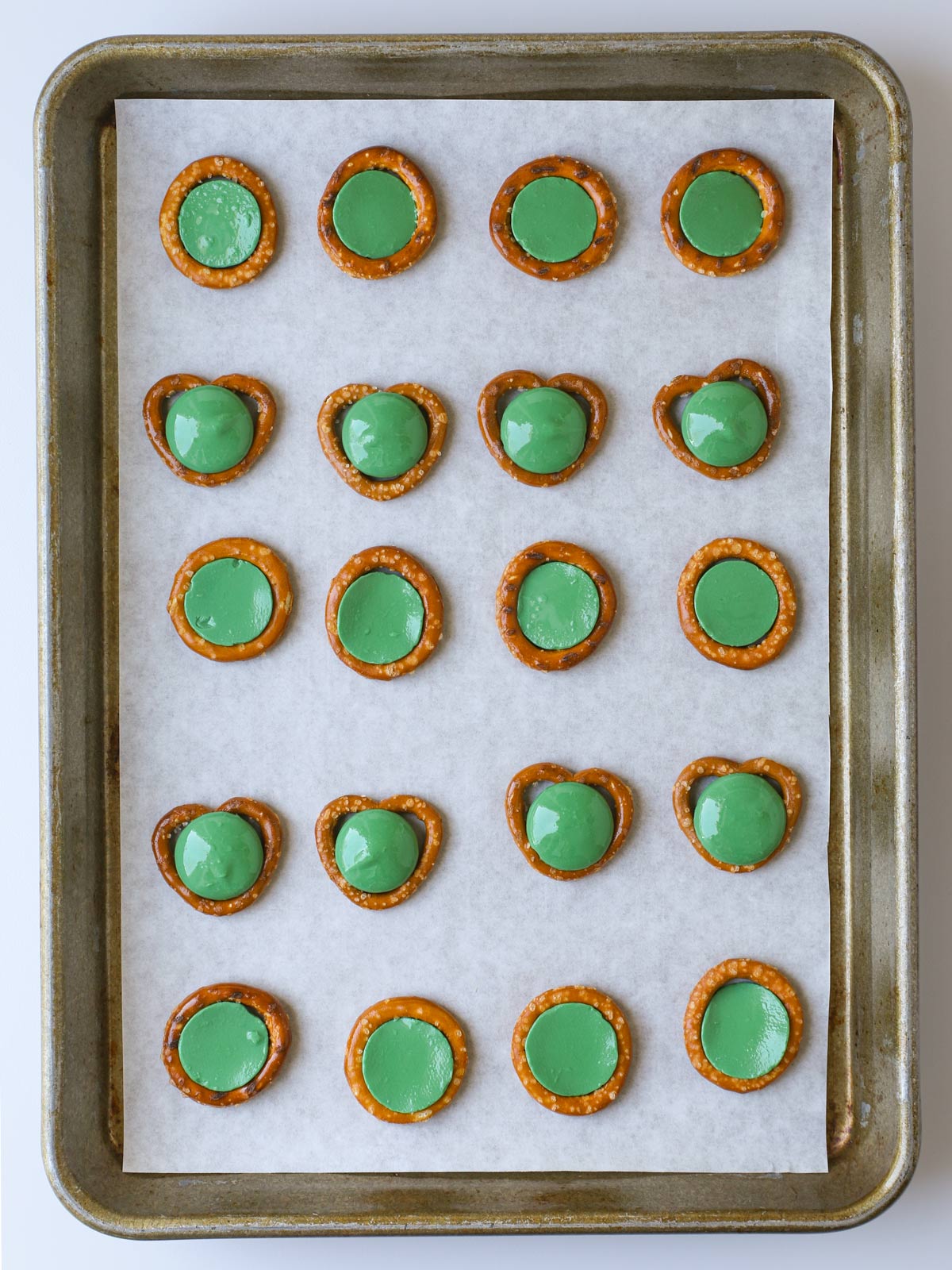 green candy melts laid atop the pretzels.