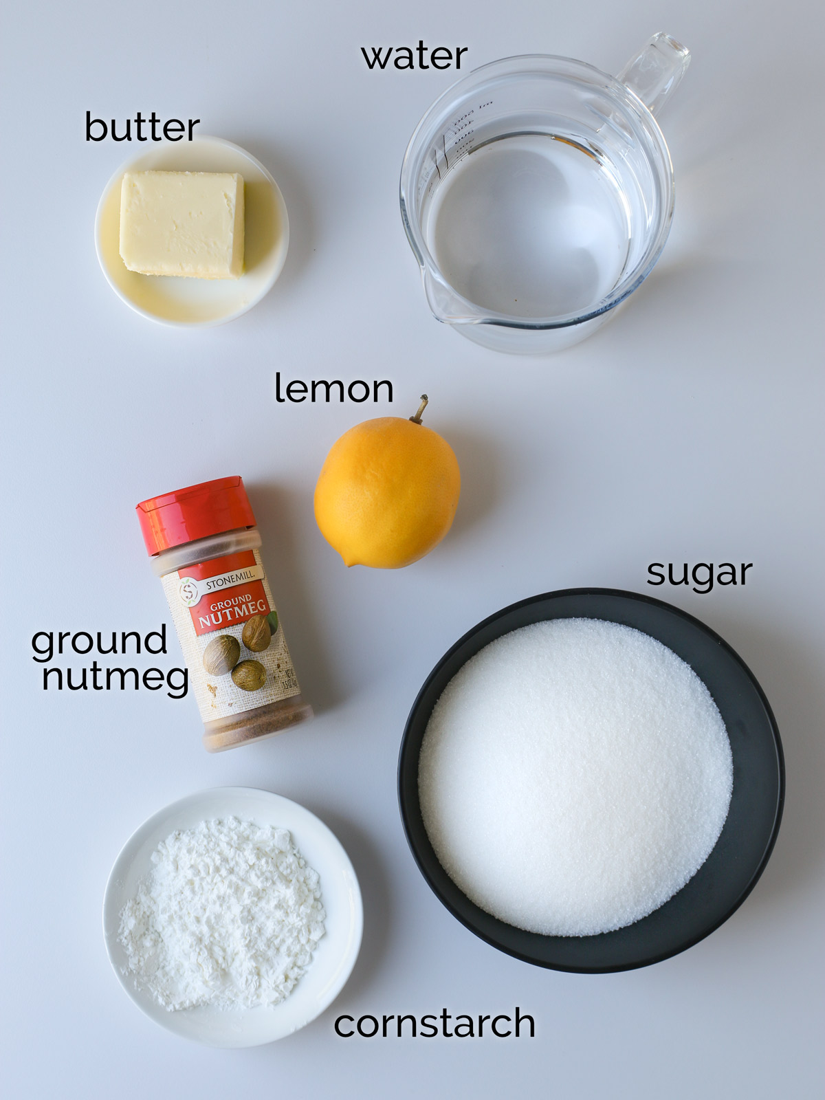 ingredients for lemon sauce laid out on white table.