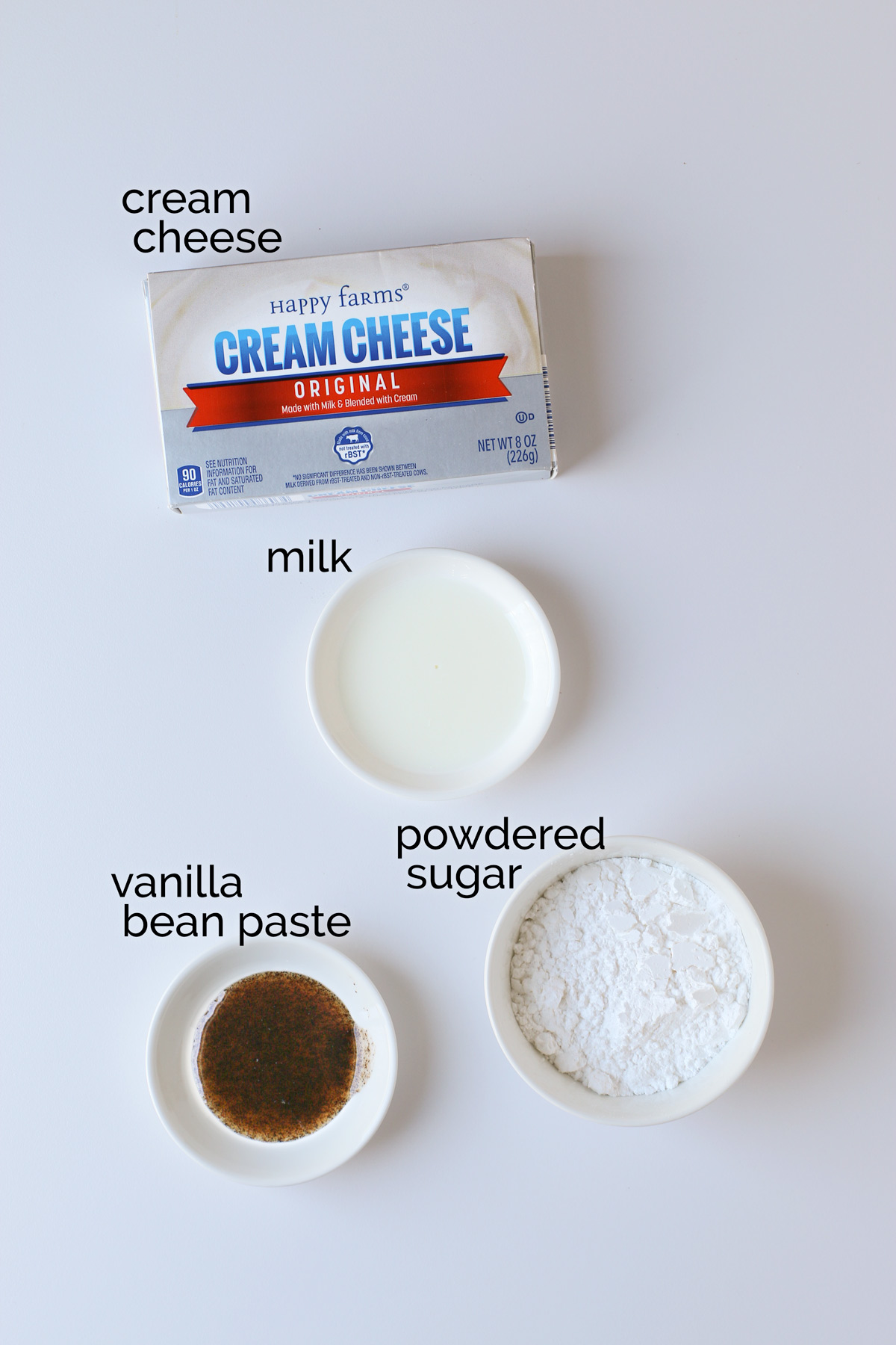 ingredients for sweet cream cheese laid out on white table.