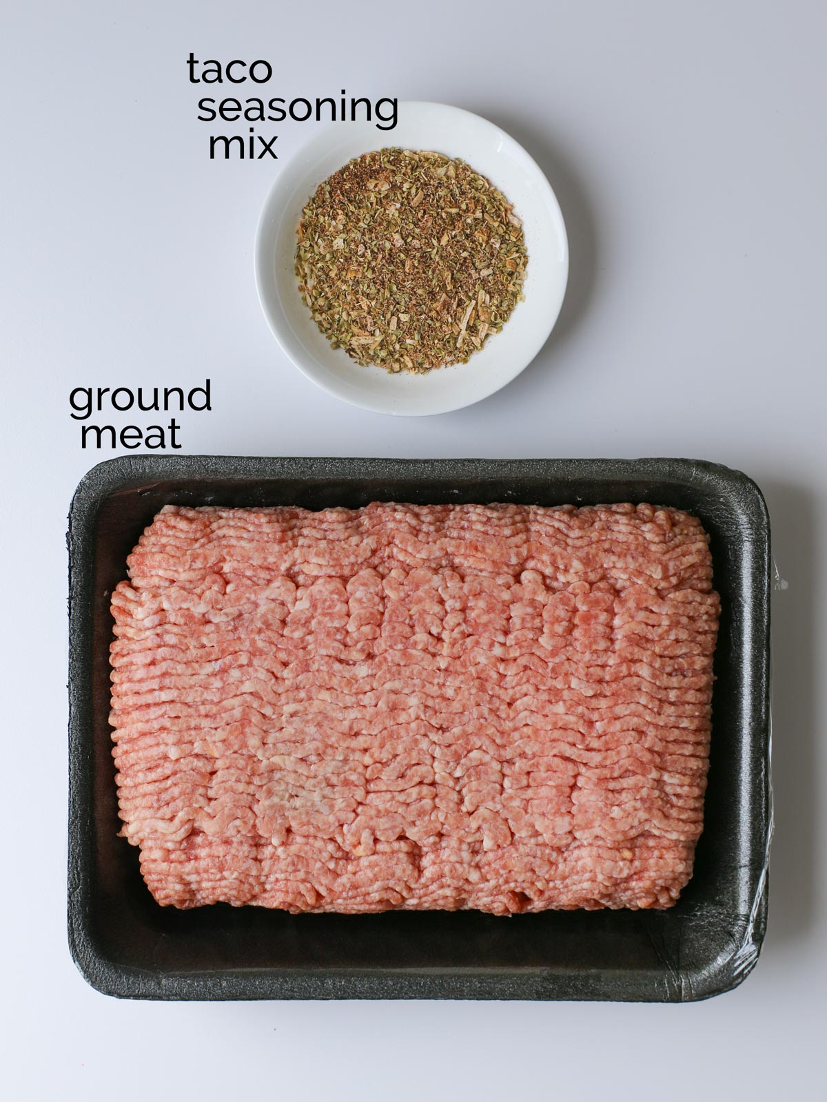 ground meat and taco seasoning mix on white counter.
