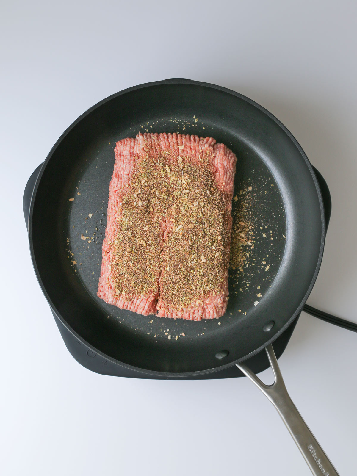 meat and seasoning in skillet prior to cooking.