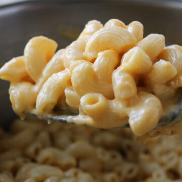 instant pot mac and cheese on a spoon over the pot.