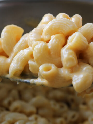 instant pot mac and cheese on a spoon over the pot.