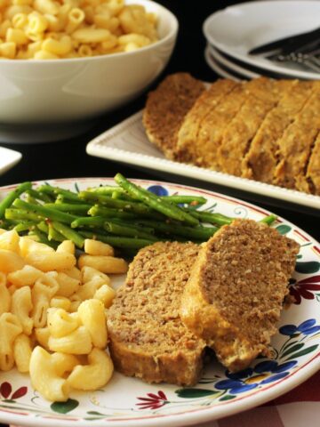 dinner plate with mac and cheese, meatloaf, and green beans.