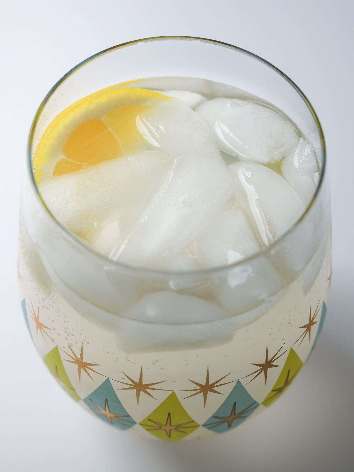 glass of ginger ale with ice and lemon.