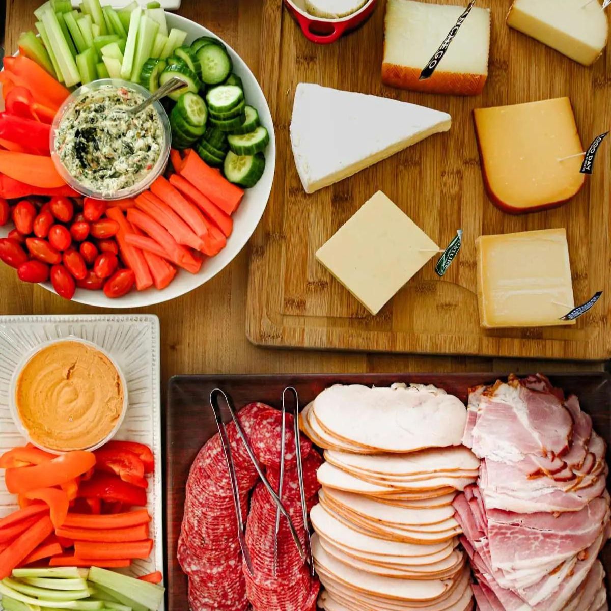 buffet of party food laid on wood table.