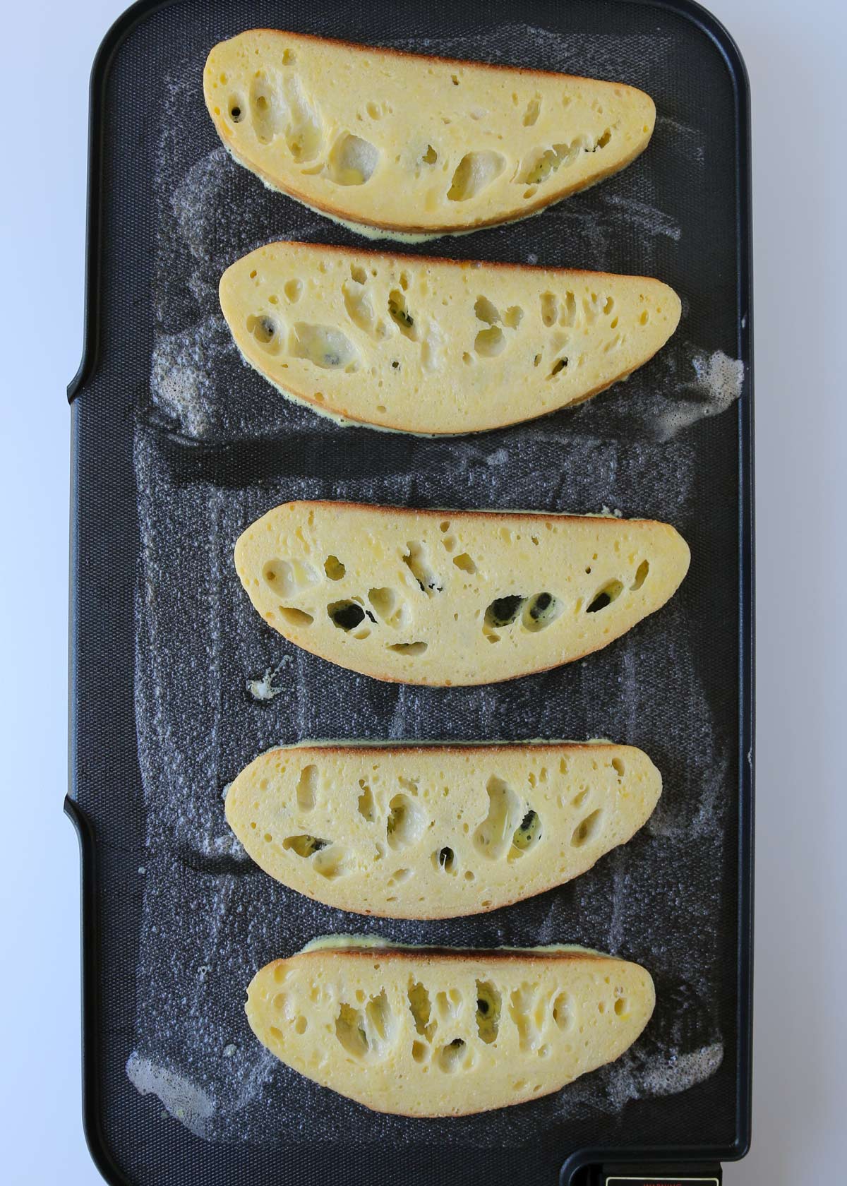 unbaked slices on buttered griddle.