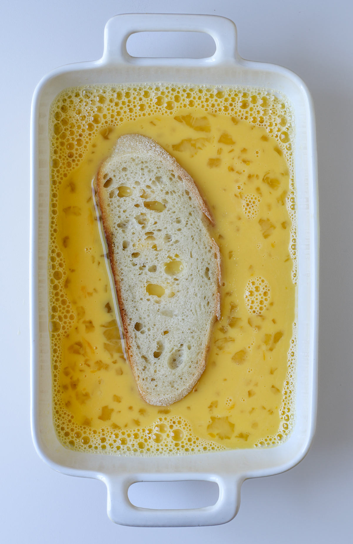 slice of bread in egg mixture in small baking dish.