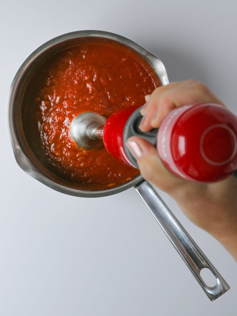 blending the sauce with an immersion blender.
