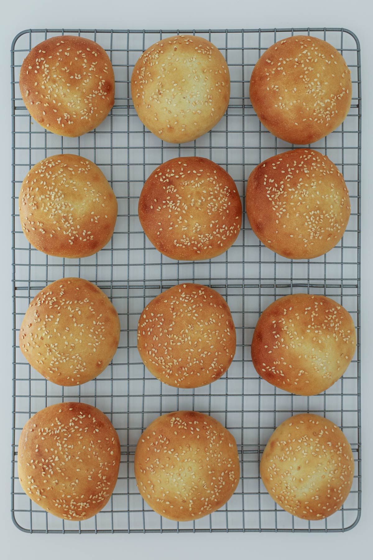 baked hamburger buns cooling on wire rack.