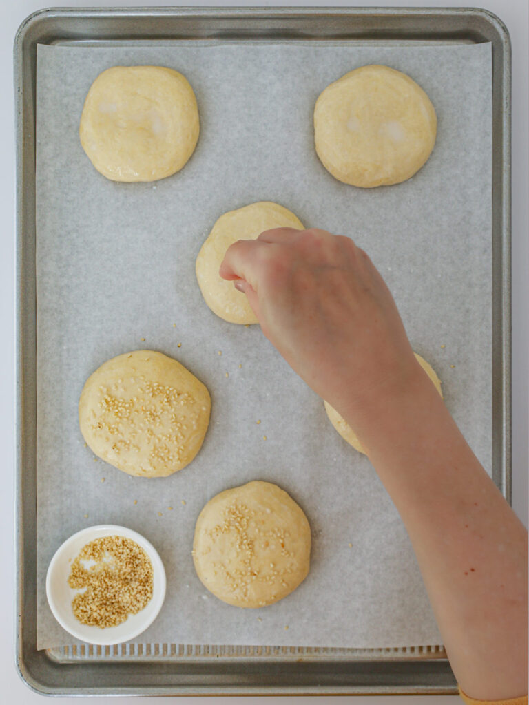 sprinkling sesame seeds over the buns prior to baking.