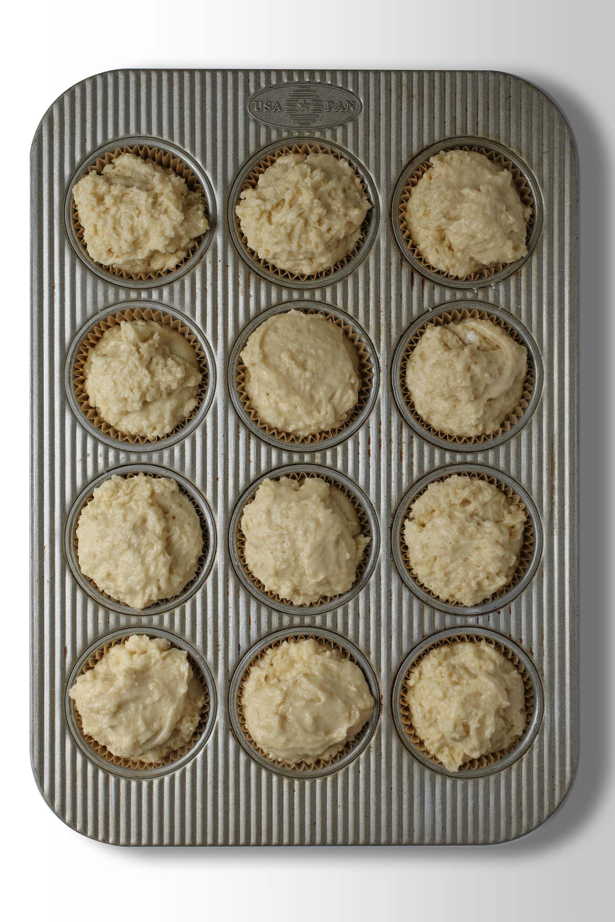 muffin batter scooped into baking pans.