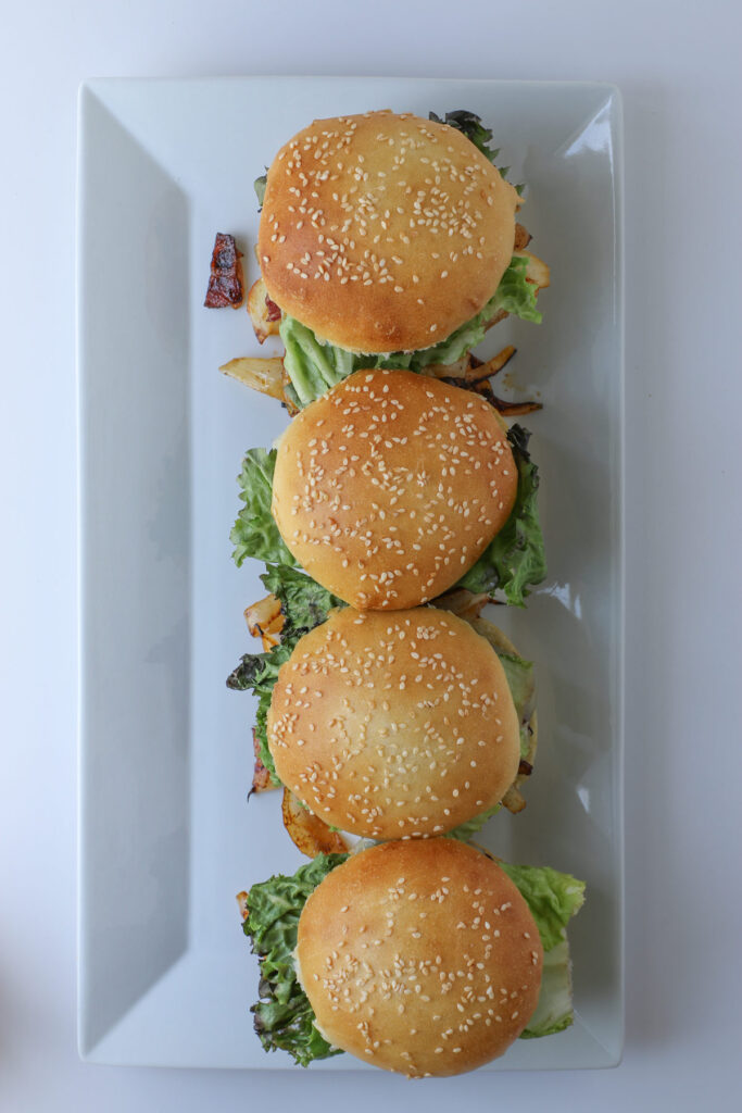 the completed bbq bacon burgers on the rectangular platter.