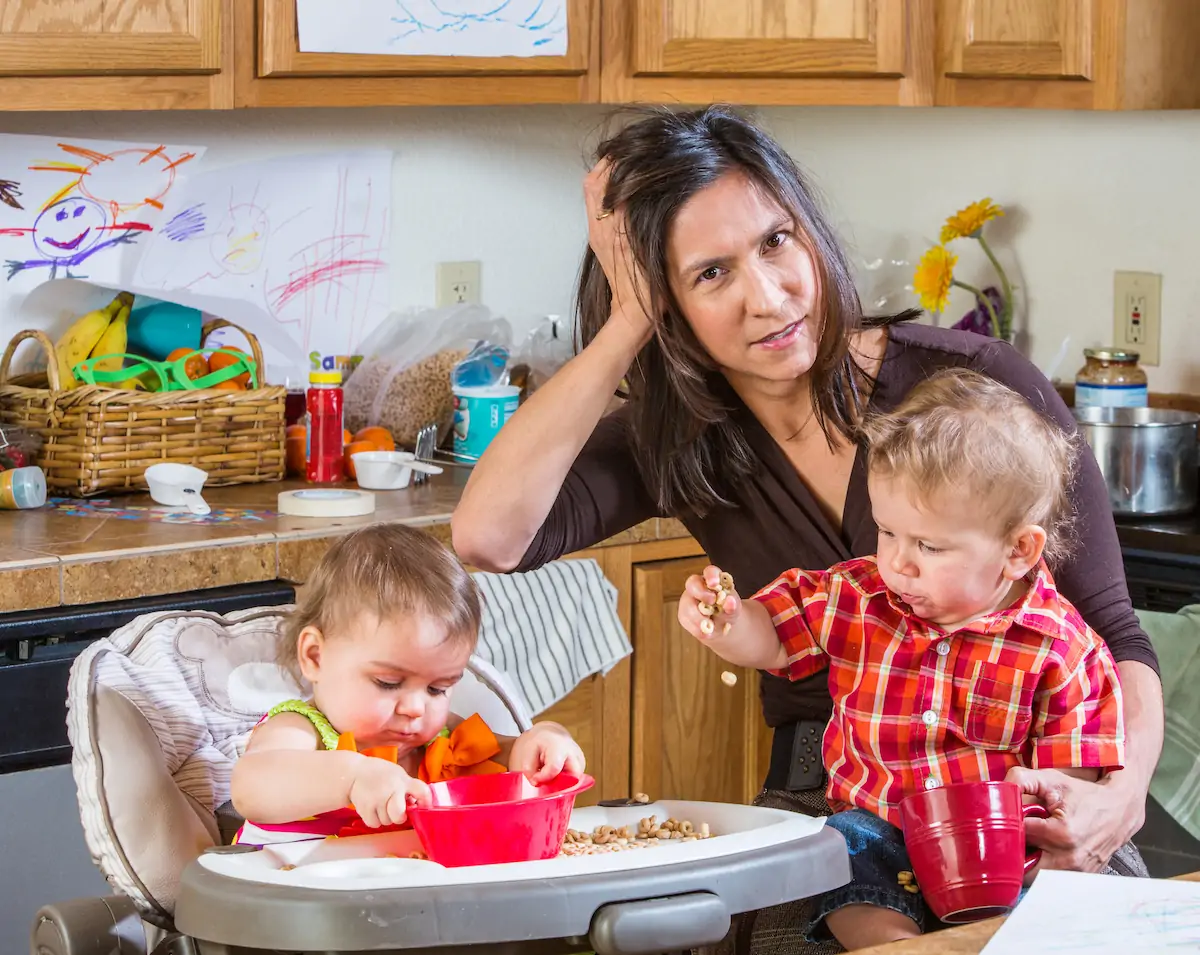 Stressed out mother in kitchen with her babies.