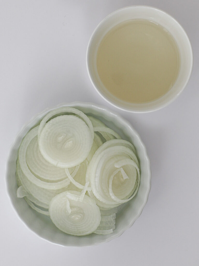 sliced onions and white vinegar in separate dishes.