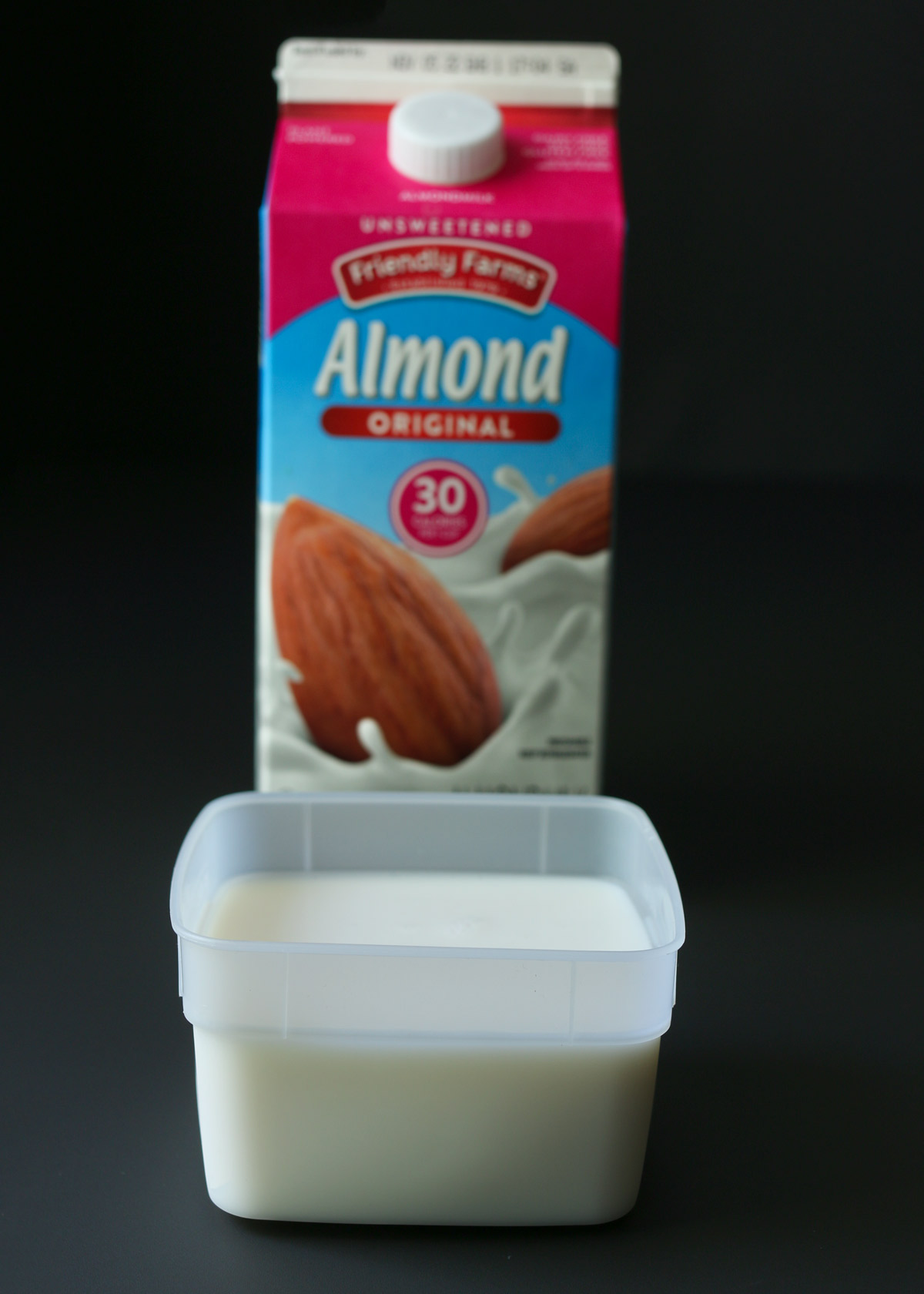 carton of almond milk behind a smaller container of almond milk for freezing.