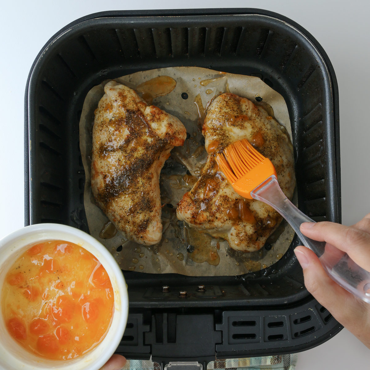 brushing the cooked turkey breast with apricot glaze.