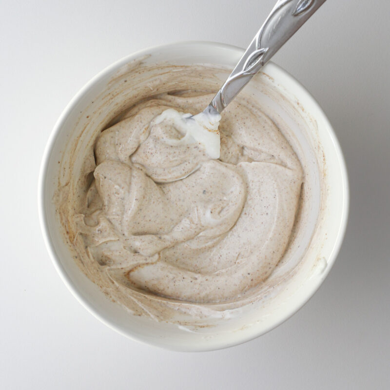 the mixed yogurt dip in the bowl with a spoon.