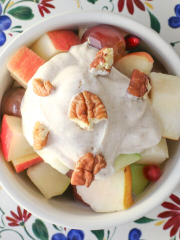 overhead shot of thanksgiving fruit salad topped with greek yogurt and chopped pecans.