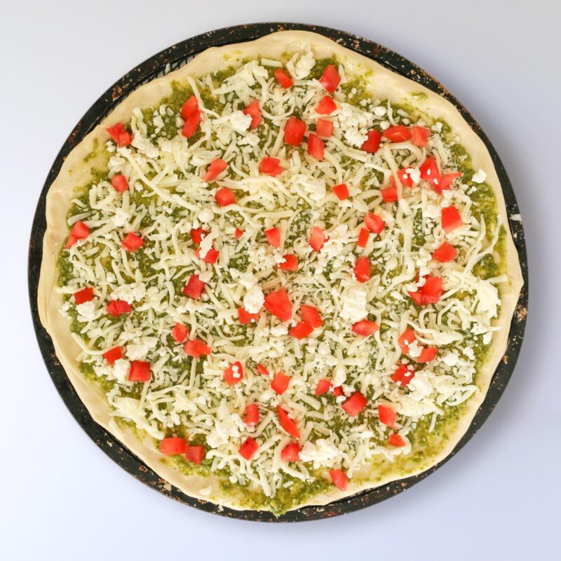 tomatoes scattered across the top of the pizza.