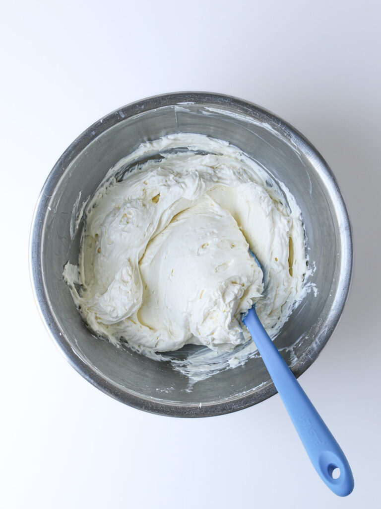 folding the cream cheese and whipped cream together with a rubber spatula.