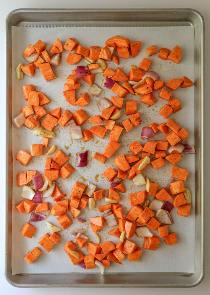 the vegetables spread out on the prepared baking sheet.