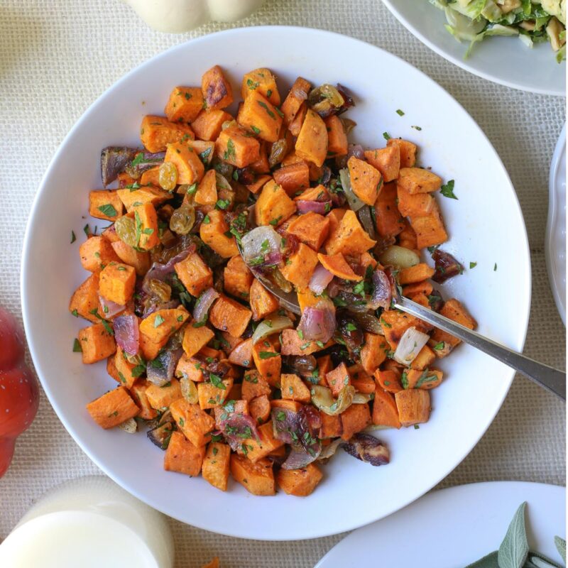 overhead shot of bowl of sweet potato salad on holiday table.