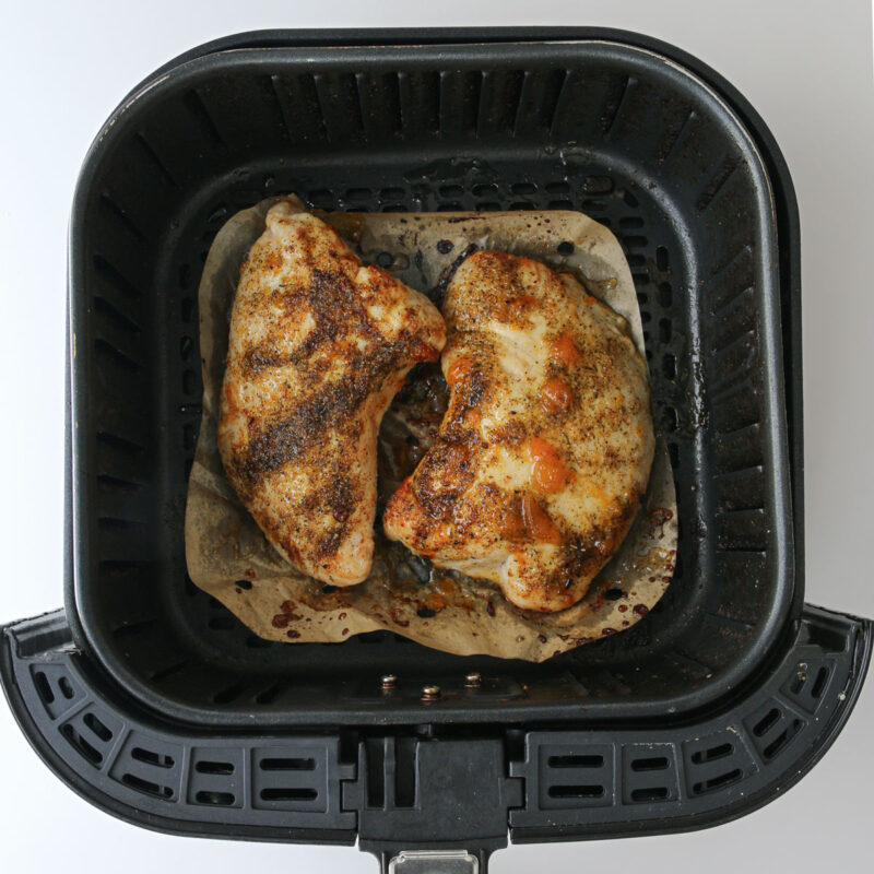 cooked turkey tenderloins in air fryer basket.
