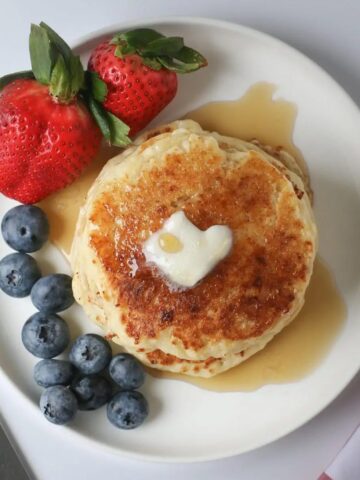Overhead shot of pancake stack with heart shaped butter pat.